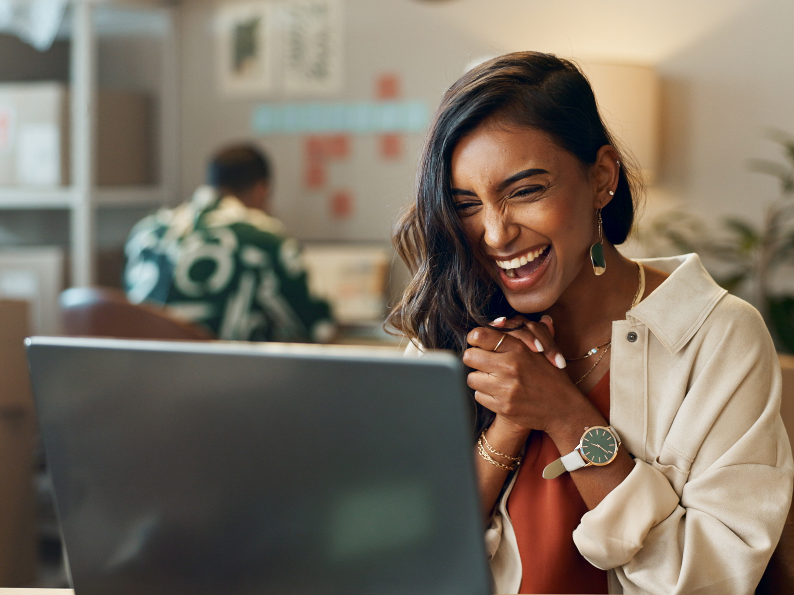 an excited woman using a laptop
